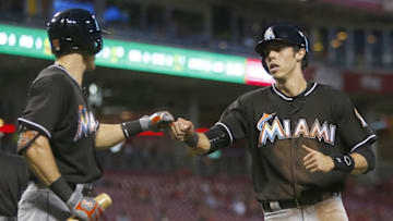 Aug 17, 2016; Cincinnati, OH, USA; Miami Marlins left fielder Christian Yelich (right) is congratulated by first baseman Derek Dietrich (left) after Yelich scored during the fifth inning against the Cincinnati Reds at Great American Ball Park. Mandatory Credit: David Kohl-USA TODAY Sports