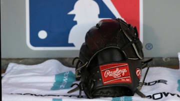 ANAHEIM, CA - SEPTEMBER 15: A Rawlings baseball glove sits in the Seattle Mariners dugout in front of an MLB logo before a game with the Los Angeles Angels of Anaheim at Angel Stadium on September 15, 2018 in Anaheim, California. (Photo by John McCoy/Getty Images)