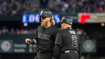 SEATTLE, WA - AUGUST 23: Jake Fraley #8 of the Seattle Mariners is congratulated by first base coach Perry Hill after his first major league hit in the second inning against the Toronto Blue Jays at T-Mobile Park on August 23, 2019 in Seattle, Washington. Teams are wearing special color schemed uniforms with players choosing nicknames to display for Players' Weekend. (Photo by Lindsey Wasson/Getty Images)