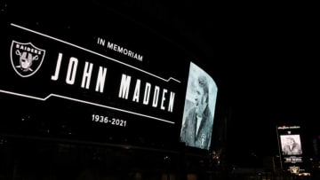 LAS VEGAS, NEVADA - DECEMBER 28: A tribute to former Raiders head coach, Pro Football Hall of Fame member and broadcaster John Madden is displayed on a marquee and on the side of Allegiant Stadium, home of the Las Vegas Raiders, after news of his death at the age of 85 on December 28, 2021 in Las Vegas, Nevada. Madden coached the Oakland Raiders for 10 seasons and won the team's first championship with a win over the Minnesota Vikings in Super Bowl XI in 1977. Owner and managing general partner Mark Davis of the Las Vegas Raiders lit the Al Davis Memorial Torch inside the stadium before the organization turned off all the exterior lights, except for the memorial message, in honor of Madden. (Photo by Ethan Miller/Getty Images)