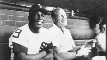 Minnie Minoso, left, and owner Bill Veeck of the Chicago White Sox enjoy a laugh in the Comiskey Park dugout in 1957. (Photo by Mark Rucker/Transcendental Graphics, Getty Images)