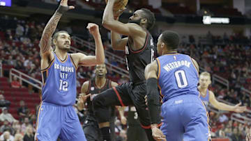 Jan 5, 2017; Houston, TX, USA; Houston Rockets guard James Harden (13) splits the defense of Oklahoma City Thunder center Steven Adams (12) and guard Russell Westbrook (0) in the first quarter at Toyota Center. Mandatory Credit: Thomas B. Shea-USA TODAY Sports