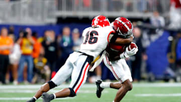 ATLANTA, GEORGIA - DECEMBER 04: Jameson Williams #1 of the Alabama Crimson Tide is tackled by Lewis Cine #16 of the Georgia Bulldogs in the second quarter of the SEC Championship game at Mercedes-Benz Stadium on December 04, 2021 in Atlanta, Georgia. (Photo by Todd Kirkland/Getty Images)