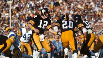 PASADENA, CA- JANUARY 20: Terry Bradshaw #12 of the Pittsburgh Steelers turns and hands the ball off to running back Rocky Bleier #20 against the Los Angeles Rams during Super Bowl XIV on January 20, 1980 at the Rose Bowl in Pasadena, California. The Steelers won the Super Bowl 31-19. (Photo by Focus on Sport/Getty Images)