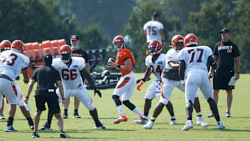 CINCINNATI, OH - AUGUST 24: Joe Burrow #9 of the Cincinnati Bengals runs a play as head coach Zac Taylor looks on during training camp workouts at the practice field outside of Paul Brown Stadium on August 24, 2020 in Cincinnati, Ohio. (Photo by Joe Robbins/Getty Images)