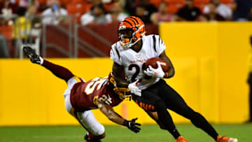 Aug 20, 2021; Landover, Maryland, USA; Cincinnati Bengals running back Chris Evans (25) breaks the tackle by Washington Football Team cornerback Benjamin St-Juste (25) during the second quarter at FedExField. Mandatory Credit: Brad Mills-USA TODAY Sports