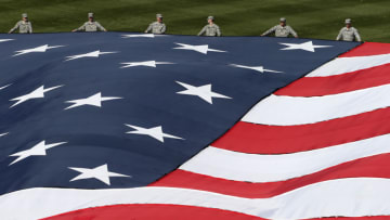 Servicemen hold a giant American flag at a Philadelphia Phillies game (Photo by Rich Schultz/Getty Images)
