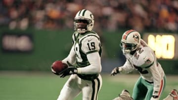 12 Dec 1999: Keyshawn Johnson #19 of the New York Jets runs for a touchdown as Shawn Wooden #22 of the Miami Dolphins is right behind him during the game at the Meadowlands in East Rutherford, New Jersey. The Jets defeated the Dolphins 28-20. Mandatory Credit: Al Bello /Allsport