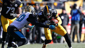 PITTSBURGH, PA - JANUARY 14: Telvin Smith #50 of the Jacksonville Jaguars tackles Le'Veon Bell #26 of the Pittsburgh Steelers during the first half of the AFC Divisional Playoff game at Heinz Field on January 14, 2018 in Pittsburgh, Pennsylvania. (Photo by Kevin C. Cox/Getty Images)