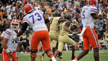 NASHVILLE, TN - OCTOBER 01: Quarterback Austin Appleby #12 of the Florida Gators is helped to his feet by teammate Martez Ivey #73 as Torren McGaster #5 of the Vanderbilt Commodores celebrates recoving a fumble during the late moments of the second half at Vanderbilt Stadium on October 1, 2016 in Nashville, Tennessee. (Photo by Frederick Breedon/Getty Images)