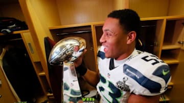 EAST RUTHERFORD, NJ - FEBRUARY 02: Linebacker Malcolm Smith #53 of the Seattle Seahawks celebrates with the Vince Lombardi Trophy after in the locker room after the 43-8 victory over the Denver Broncos during Super Bowl XLVIII at MetLife Stadium on February 2, 2014 in East Rutherford, New Jersey. (Photo by Kevin C. Cox/Getty Images)