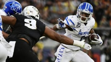ORLANDO, FLORIDA - DECEMBER 01: Trysten Hill #9 of the UCF Knights takes down Tony Pollard #1 of the Memphis Tigers for a loss of two yards during the first quarter of the American Athletic Championship at Spectrum Stadium on December 01, 2018 in Orlando, Florida. (Photo by Julio Aguilar/Getty Images)