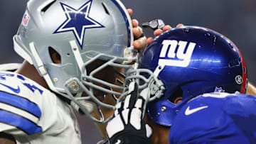 ARLINGTON, TX - SEPTEMBER 13: (L-R) Tyron Smith #77 of the Dallas Cowboys and Cullen Jenkins #99 of the New York Giants get their helmets stuck in the third quarter at AT&T Stadium on September 13, 2015 in Arlington, Texas. (Photo by Ronald Martinez/Getty Images)