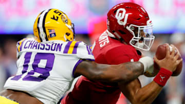 ATLANTA, GEORGIA - DECEMBER 28: Quarterback Jalen Hurts #1 of the Oklahoma Sooners is tackled by the linebacker K'Lavon Chaisson #18 of the LSU Tigers during the Chick-fil-A Peach Bowl at Mercedes-Benz Stadium on December 28, 2019 in Atlanta, Georgia. (Photo by Kevin C. Cox/Getty Images)