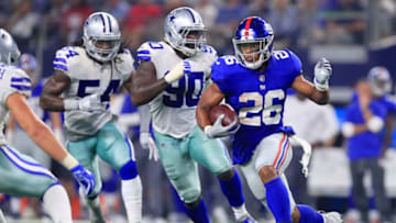ARLINGTON, TX - SEPTEMBER 16: Saquon Barkley #26 of the New York Giants carries the ball against DeMarcus Lawrence #90 of the Dallas Cowboys and Jaylon Smith #54 of the Dallas Cowboys in the fourth quarter at AT&T Stadium on September 16, 2018 in Arlington, Texas. (Photo by Tom Pennington/Getty Images)