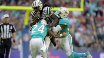 Oct 4, 2015; London, United Kingdom; New York Jets running back Chris Ivory (33) is defended by Miami Dolphins safety Rashad Jones (20) and cornerback Brice McCain (24) in Game 12 of the NFL International Series at Wembley Stadium. Mandatory Credit: Kirby Lee-USA TODAY Sports