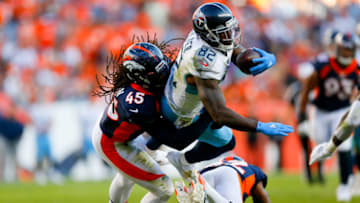 DENVER, CO - OCTOBER 13: Tight end Delanie Walker #82 of the Tennessee Titans leaps with the football over defensive back Kareem Jackson #22 of the Denver Broncos while being tackled by linebacker A.J. Johnson #45 during the fourth quarter at Empower Field at Mile High on October 13, 2019 in Denver, Colorado. The Broncos defeated the Titans 16-0. (Photo by Justin Edmonds/Getty Images)