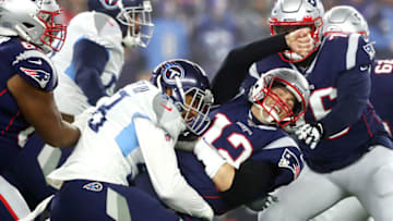 FOXBOROUGH, MASSACHUSETTS - JANUARY 04: Tom Brady #12 of the New England Patriots is hit as he throws the ball by Harold Landry #58 of the Tennessee Titans in the first quarter of the AFC Wild Card Playoff game at Gillette Stadium on January 04, 2020 in Foxborough, Massachusetts. (Photo by Adam Glanzman/Getty Images)