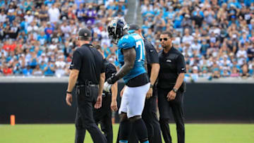 JACKSONVILLE, FL - SEPTEMBER 16: Cam Robinson #74 of the Jacksonville Jaguars is helped off the field by medical personal in the first half against the New England Patriots at TIAA Bank Field on September 16, 2018 in Jacksonville, Florida. (Photo by Sam Greenwood/Getty Images)