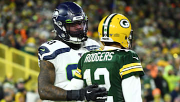 GREEN BAY, WISCONSIN - JANUARY 12: Jadeveon Clowney #90 of the Seattle Seahawks stands with Aaron Rodgers #12 of the Green Bay Packers during the first half in the NFC Divisional Playoff game at Lambeau Field on January 12, 2020 in Green Bay, Wisconsin. (Photo by Stacy Revere/Getty Images)
