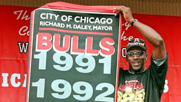 Michael Jordan, of the Chicago Bulls holds a banner given to him by the city of Chicago 16 June at a celebration in Grant Park in Chicago, IL. The Bulls won the NBA Championship for the fifth time in seven years beating the Utah Jazz four games to two. AFP PHOTO/JEFF HAYNES (Photo by JEFF HAYNES / AFP) (Photo credit should read JEFF HAYNES/AFP via Getty Images)