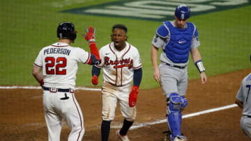 ATLANTA, GEORGIA - OCTOBER 17: Ozzie Albies #1 of the Atlanta Braves is congratulated by Joc Pederson #22 after he slide past Will Smith #16 to score in the eighth inning of Game Two of the National League Championship Series at Truist Park on October 17, 2021 in Atlanta, Georgia. (Photo by Michael Zarrilli/Getty Images)