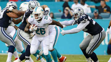 Nov 22, 2015; Miami Gardens, FL, USA; Dallas Cowboys defensive end Greg Hardy (76) tackles Miami Dolphins running back Lamar Miller (26) during the first half at Sun Life Stadium. Mandatory Credit: Steve Mitchell-USA TODAY Sports