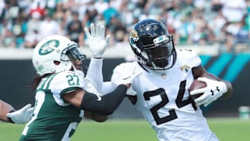 JACKSONVILLE, FL - SEPTEMBER 30: T.J. Yeldon #24 of the Jacksonville Jaguars fights off the tackle of Darryl Roberts #27 of the New York Jets during their game at TIAA Bank Field on September 30, 2018 in Jacksonville, Florida. (Photo by Scott Halleran/Getty Images)