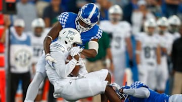 LEXINGTON, KY - SEPTEMBER 30: Antoine Porter #21 of the Eastern Michigan Eagles is tackled by Lonnie Johnson #6 and Mike Edwards #7 of the Kentucky Wildcats at Commonwealth Stadium on September 30, 2017 in Lexington, Kentucky. (Photo by Michael Hickey/Getty Images)