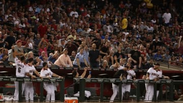 PHOENIX, AZ - AUGUST 09: Fans and players attempt to catch a thrown bat from J.D. Martinez (not pictured) of the Arizona Diamondbacks during the fourth inning of the MLB game against the Los Angeles Dodgers at Chase Field on August 9, 2017 in Phoenix, Arizona. (Photo by Christian Petersen/Getty Images)