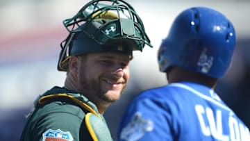 Mar 26, 2016; Surprise, AZ, USA; Oakland Athletics catcher Stephen Vogt (21) talks with Kansas City Royals shortstop Christian Colon (24) during the fifth inning at Surprise Stadium. Mandatory Credit: Joe Camporeale-USA TODAY Sports