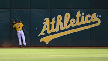 Sep 9, 2015; Oakland, CA, USA; Oakland Athletics left fielder Coco Crisp (4) collides into the wall on a double by Houston Astros center fielder Carlos Gomez (not pictured) during the fifth inning at O.co Coliseum. Mandatory Credit: Kelley L Cox-USA TODAY Sports