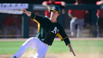 Mar 7, 2015; Mesa, AZ, USA; Oakland Athletics second baseman Joe Wendle (52) slides at home plate and scores a run against the Los Angeles Angels during a spring training baseball game at HoHoKam Stadium. Mandatory Credit: Joe Camporeale-USA TODAY Sports