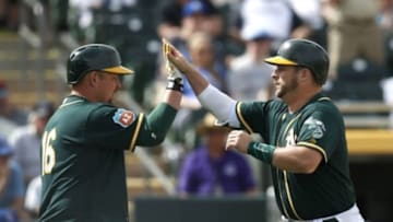 Mar 7, 2016; Mesa, AZ, USA; Oakland Athletics catcher Stephen Vogt (21) celebrates with Billy Butler (16) after hitting a solo home run against the Kansas City Royals in the fourth inning during a spring training game at HoHoKam Stadium. Mandatory Credit: Rick Scuteri-USA TODAY Sports