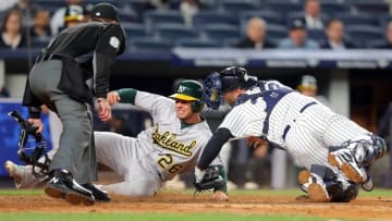 Apr 20, 2016; Bronx, NY, USA; Oakland Athletics third baseman Danny Valencia (26) is tagged out by New York Yankees catcher Brian McCann (34) while trying to score on a fly ball by Oakland Athletics first baseman Yonder Alonso (not pictured) during the fourth inning at Yankee Stadium. Mandatory Credit: Brad Penner-USA TODAY Sports