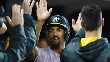 Apr 25, 2016; Detroit, MI, USA; Oakland Athletics shortstop Marcus Semien (10) is congratulated by teammates after scoring in the sixth inning against the Detroit Tigers at Comerica Park. Mandatory Credit: Rick Osentoski-USA TODAY Sports