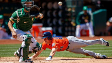 OAKLAND, CA - JUNE 02: Myles Straw #26 of the Houston Astros dives into home plate to score a run ahead of a tag from Nick Hundley #3 of the Oakland Athletics during the fifth inning at the Oakland Coliseum on June 2, 2019 in Oakland, California. (Photo by Jason O. Watson/Getty Images)