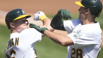 OAKLAND, CALIFORNIA - APRIL 17: Matt Olson #28 and Matt Chapman #26 of the Oakland Athletics celebrates after Olson hit a solo home run against the Detroit Tigers in the first inning at RingCentral Coliseum on April 17, 2021 in Oakland, California. (Photo by Thearon W. Henderson/Getty Images)