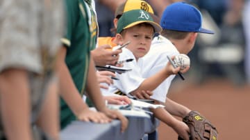 PEORIA, AZ - MARCH 05: An Oakland Athletics fan holds up his autographed ball prior to the spring training game against the Seattle Mariners at Peoria Stadium on March 5, 2017 in Peoria, Arizona. (Photo by Jennifer Stewart/Getty Images)