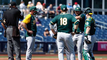 PEORIA, ARIZONA - MARCH 18: Starting pitcher Sean Manaea #55 of the Oakland Athletics talks with manager Bob Melvin, Mitch Moreland #18 and Sean Murphy #12 after being hit by a line-drive from the San Diego Padres during the first inning of the MLB spring training game at Peoria Sports Complex on March 18, 2021 in Peoria, Arizona. (Photo by Christian Petersen/Getty Images)