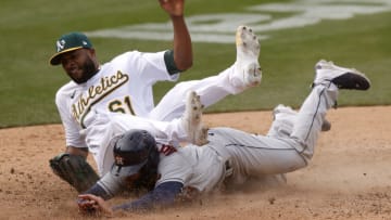 OAKLAND, CALIFORNIA - APRIL 03: Chas McCormick #6 of the Houston Astros slides safely under pitcher Reymin Guduan #61 of the Oakland Athletics after Guduan threw a wild pitch and McCormick scored from third base in the eighth inning at RingCentral Coliseum on April 03, 2021 in Oakland, California. (Photo by Ezra Shaw/Getty Images)