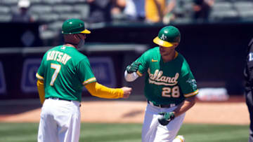 May 26, 2021; Oakland, California, USA; Oakland Athletics first baseman Matt Olson (28) gets a congratulatory fist bump from third base coach Mark Kotsay (7) after hitting a solo home run against the Seattle Mariners during the third inning at RingCentral Coliseum. Mandatory Credit: D. Ross Cameron-USA TODAY Sports