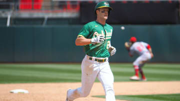 Jun 16, 2021; Oakland, California, USA; Oakland Athletics left fielder Mark Canha (20) runs to third base as Los Angeles Angels second baseman David Fletcher (22) gather the ball during the sixth inning at RingCentral Coliseum. Mandatory Credit: Kelley L Cox-USA TODAY Sports