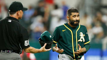 Jun 22, 2021; Arlington, Texas, USA; Oakland Athletics relief pitcher Sergio Romo (54) is checked for foreign substances by umpire Dan Iassogna (58)after the seventh inning against the Texas Rangers at Globe Life Field. Mandatory Credit: Tim Heitman-USA TODAY Sports