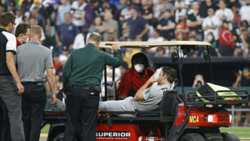 Aug 17, 2021; Chicago, Illinois, USA; Medical personnel helps Oakland Athletics starting pitcher Chris Bassitt (40) who covers his face after being hit by a ball hit by Chicago White Sox left fielder Brian Goodwin during the second inning at Guaranteed Rate Field. Mandatory Credit: Kamil Krzaczynski-USA TODAY Sports