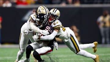 ATLANTA, GA - NOVEMBER 28: Calvin Ridley #18 of the Atlanta Falcons is tackled by Demario Davis #56 of the New Orleans Saints and Marshon Lattimore #23 during the second half of an NFL game at Mercedes-Benz Stadium on November 28, 2019 in Atlanta, Georgia. (Photo by Todd Kirkland/Getty Images)