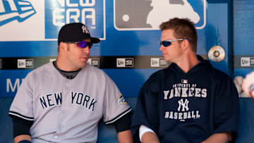 TORONTO, ON - SEPTEMBER 06: Eric Hinske #14 (L) and A.J. Burnett #34 (R) of the New York Yankees talk in the dugout before the game against the Toronto Blue Jays on September 6, 2009 at the Rogers Centre in Toronto, Canada. (Photo by Paul Giamou/Getty Images)