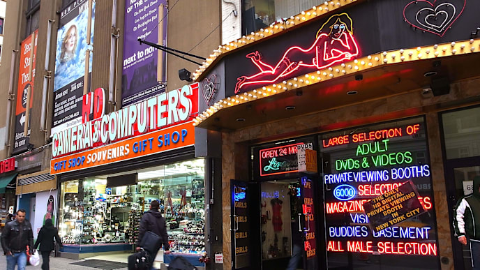 NEW YORK, NY - DECEMBER 06: People walk past one of the few remaining sex shops in the area along 8th avenue next to Times Square on December 6, 2010 in New York City. Times Square, once a haven for prostitution and pornography, has been transformed over the years into a family friendly entertainment and shopping destination. One of the most famous peep show signs of the era, Peep -O-Rama, has been refurbished and moved to the visitors center run by the Times Square Alliance. Visitors can stand in genuine peep show booths to view historic articles and photographs that feature Times Square. Many critics still complain that the iconic location has been too sanitized. (Photo by Spencer Platt/Getty Images) NEW YORK, NY - DECEMBER 06: People walk past one of the few remaining sex shops in the area along 8th avenue next to Times Square on December 6, 2010 in New York City. Times Square, once a haven for prostitution and pornography, has been transformed over the years into a family friendly entertainment and shopping destination. One of the most famous peep show signs of the era, Peep -O-Rama, has been refurbished and moved to the visitors center run by the Times Square Alliance. Visitors can stand in genuine peep show booths to view historic articles and photographs that feature Times Square. Many critics still complain that the iconic location has been too sanitized. (Photo by Spencer Platt/Getty Images)