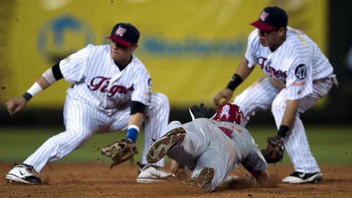 Andy Driks (C) of Dominican Leones del Escogido stills the second base in front of Miguel Rojas (L) and Luis Hernandez (R) of Venezuelan Tigres de Aragua during the fourth inning of the Caribbean Series baseball game at the Quisqueya stadium in Santo Domingo, Dominican Republic on February 3, 2012. AFP PHOTO/OMAR TORRES (Photo credit should read OMAR TORRES/AFP/Getty Images) Andy Driks (C) of Dominican Leones del Escogido stills the second base in front of Miguel Rojas (L) and Luis Hernandez (R) of Venezuelan Tigres de Aragua during the fourth inning of the Caribbean Series baseball game at the Quisqueya stadium in Santo Domingo, Dominican Republic on February 3, 2012. AFP PHOTO/OMAR TORRES (Photo credit should read OMAR TORRES/AFP/Getty Images)