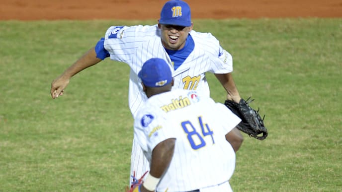 Mario Lisson (rear) and Adonis Garcia (front) of Venezuela's Navegantes del Magallanes celebrates after defeating Cuba's Azucareros de Villa Clara during their 2014 Caribbean baseball series game, on February 2, 2014, in Porlamar city, Margarita Island, Nueva Esparta state, Venezuela . AFP PHOTO / LEO RAMIREZ        (Photo credit should read LEO RAMIREZ/AFP via Getty Images)